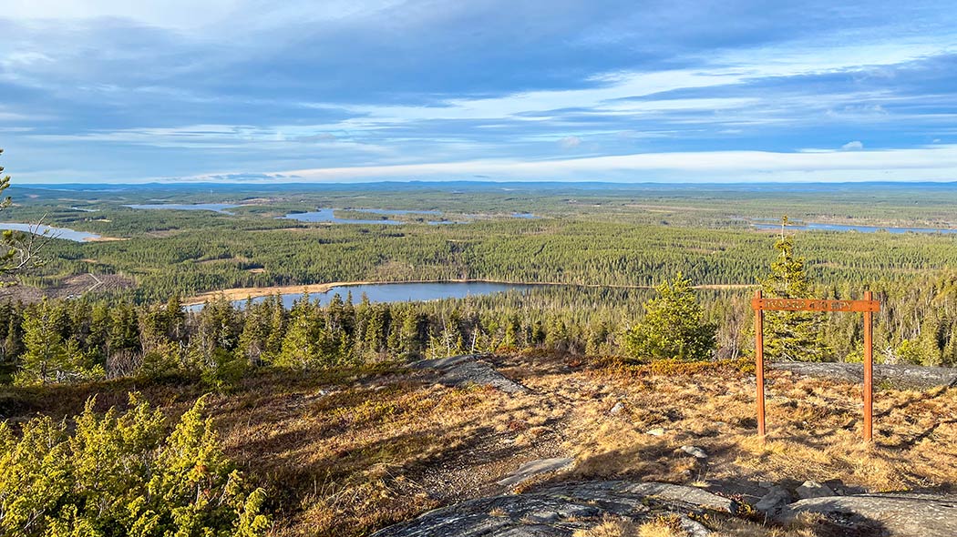 Bilden tagen från toppen av kullen visar ett öppet landskap till det omgivande området, sjöar, kullar, skogar.