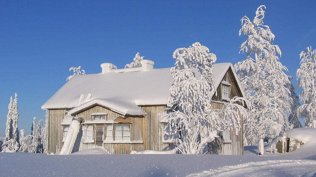 Gammal byggnad i ett snöigt landskap.